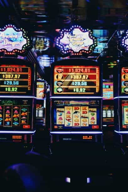 Casino interior with slot machines and colorful lights.