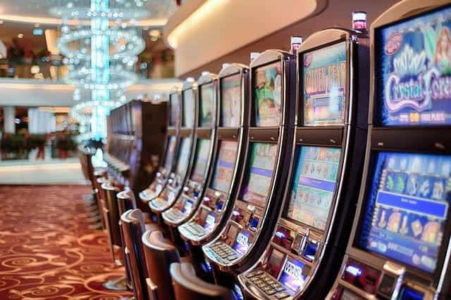 A row of slot machines in a brightly-lit casino.