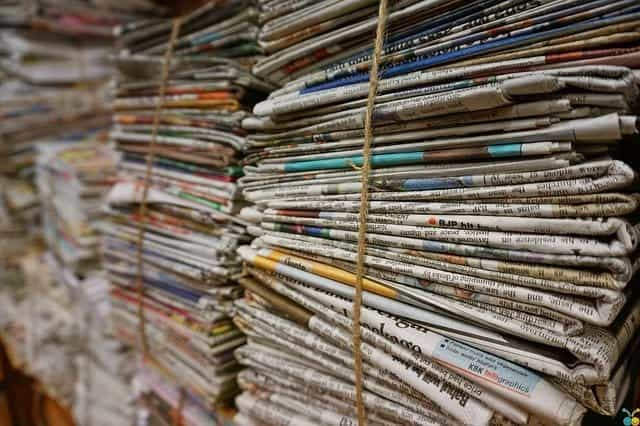 Stacks of newspapers bundled together with rope.