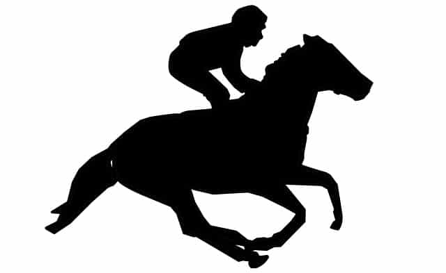 A silhouette outline of a jockey racing his horse during a race.