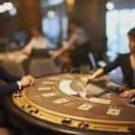 A casino table with a dealer and a player.