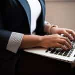 A woman typing on a laptop.