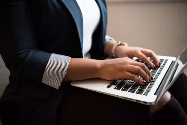 A woman typing on a laptop.