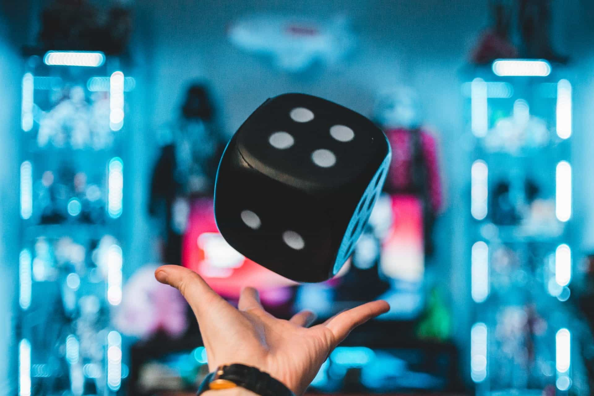 A hand playing with a giant dice.