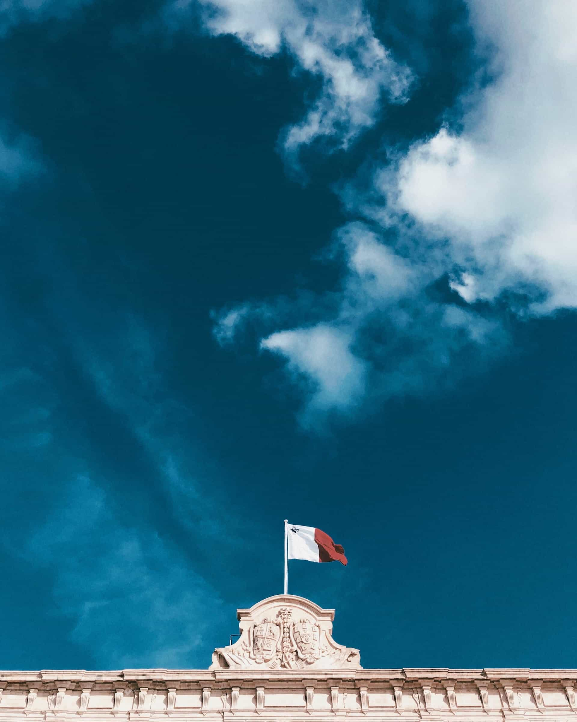 The flag of Malta flying over Valetta city.