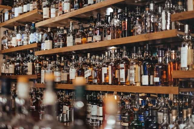 Shelves of liquor bottles lined up behind a bar.