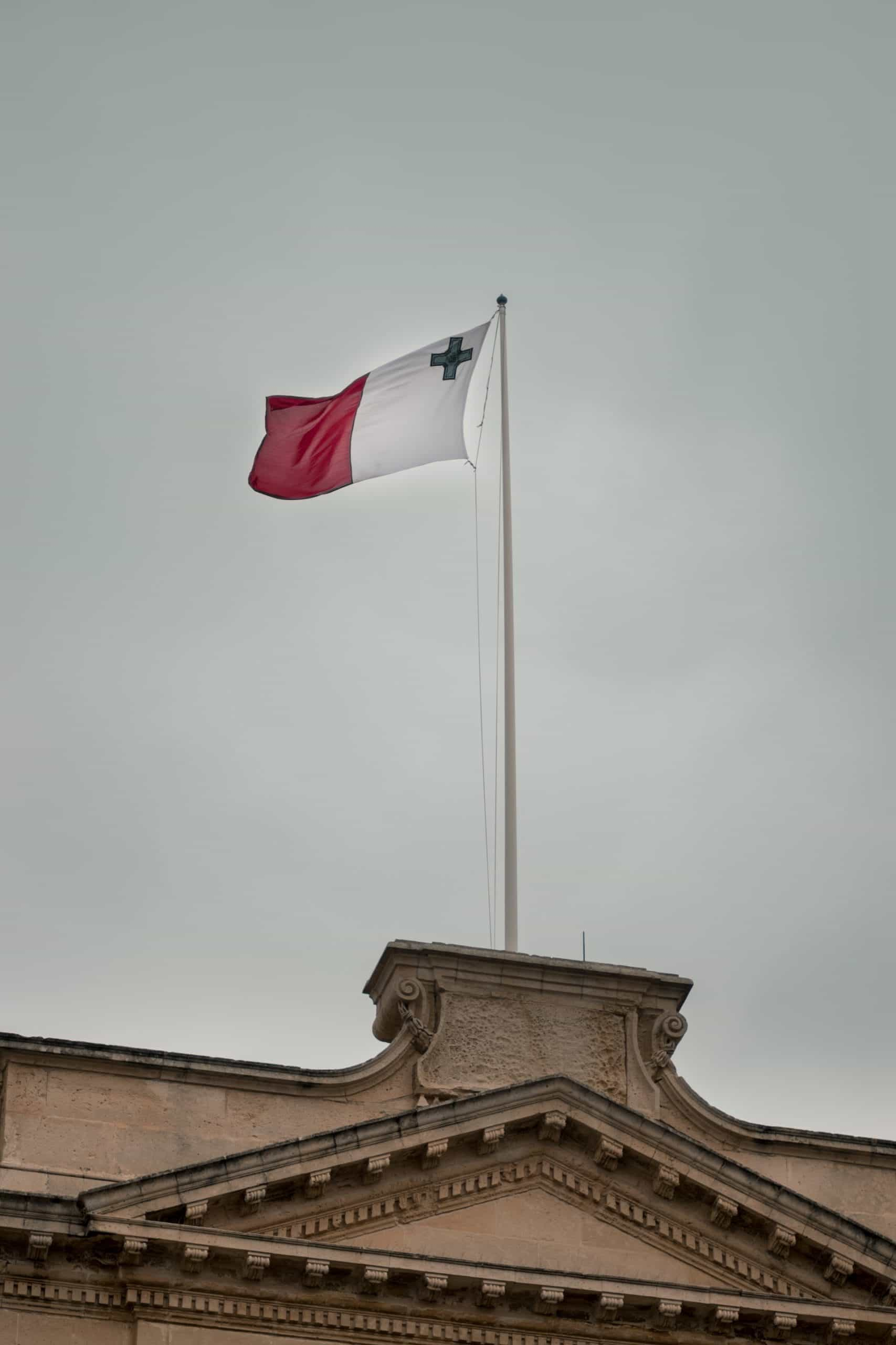 The flag of Malta against a cloudy sky