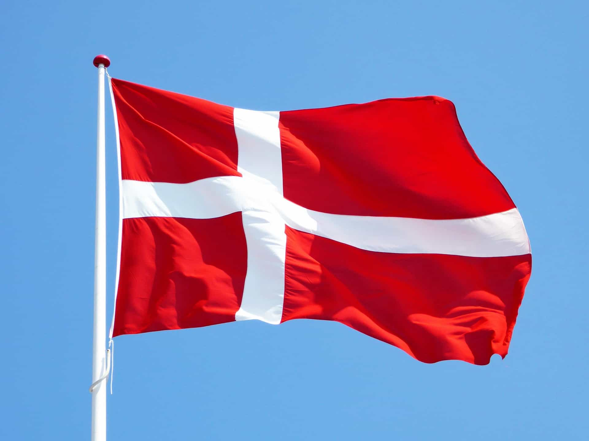 A red and white flag against the sky.