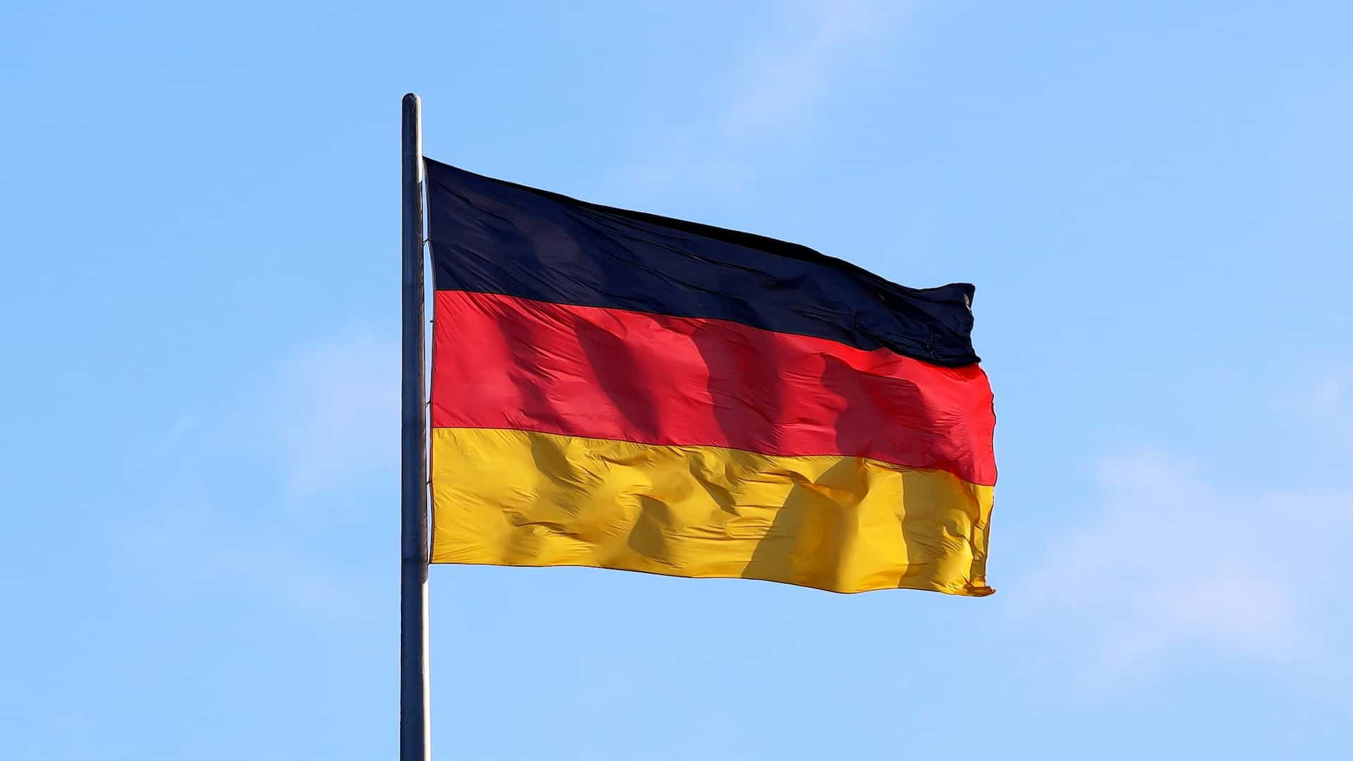 A flag waving against a blue sky.